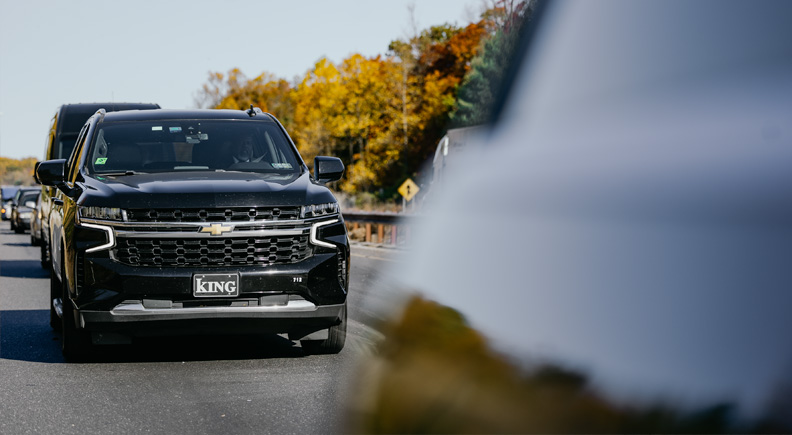 SUV driving on a road in the fall